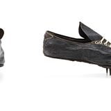 Ein Paar schwarzer Schuhe mit Stollen im vorderen Bereich