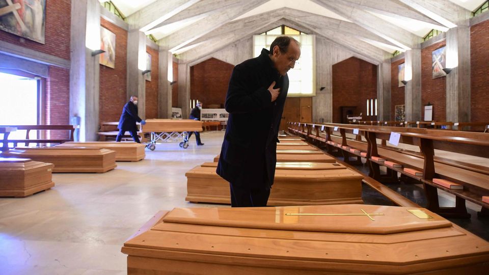Don Mario spricht Gebete für zahlreiche Corona-Tote, die in der Kirche seiner Stadt aufgebahrt wurden Don Mario spricht Gebete für zahlreiche Corona-Tote, die in der Kirche seiner Stadt aufgebahrt wurden