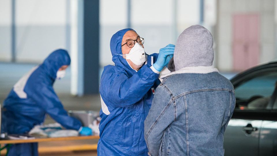  Test auf das Coronavirus: Ein Arzt nimmt in einer Halle der ehemaligen Saarbrücker Messe einen Abstrich