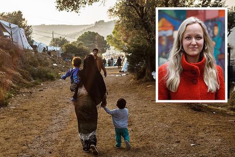 Eine Frau mit 2 Kindern läuft durch das Camp, ein Mann kommt ihr entgegen, daneben Zoe im roten Pulli vor einer bunten Wand