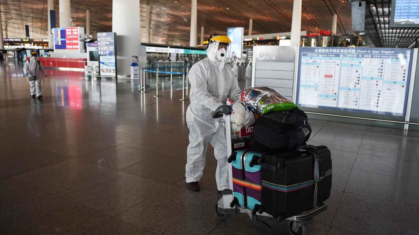 Ein Reisender in Schutzkleidung am Flughafen Peking