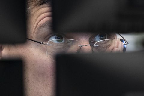 Ein Börsenhändler an der Börse Frankfurt blickt auf seine Monitore