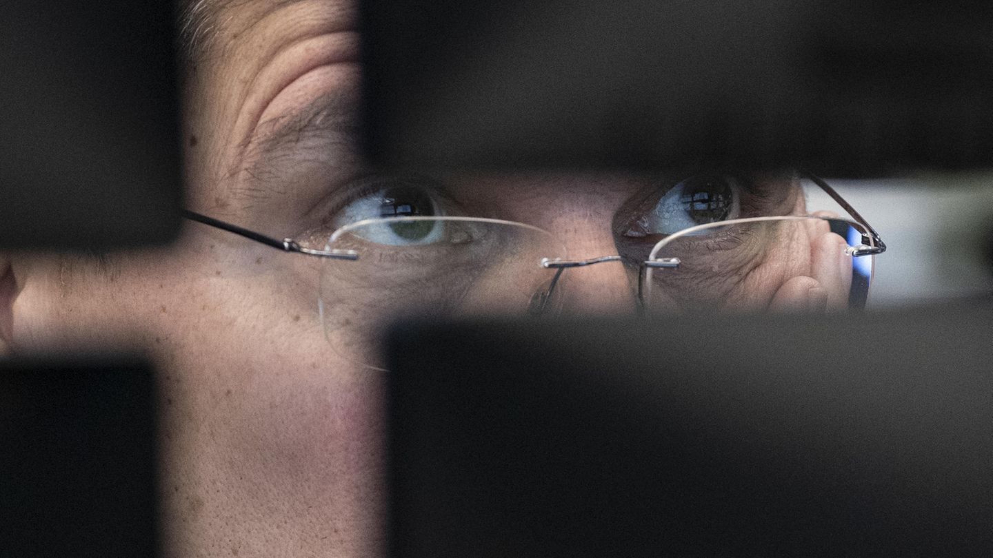 Ein Börsenhändler an der Börse Frankfurt blickt auf seine Monitore