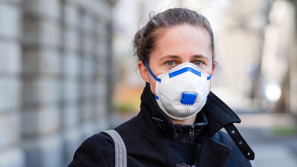 Coronavirus: Eine Frau steht auf der Straße und trägt eine Atemschutzmaske