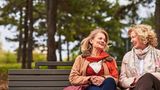 Frauen unterhalten sich auf einer Parkbank
