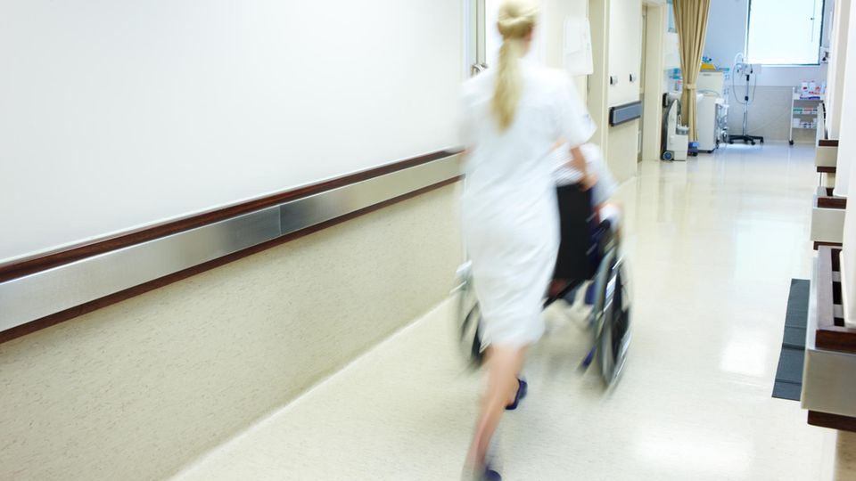 Krankenschwester mit Patient im Rollstuhl