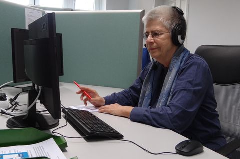 Elke Schilling von Silbernetz mit Kopfhörern am Computer