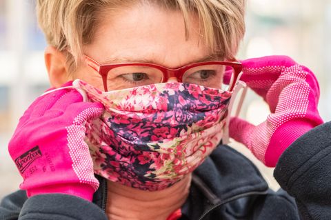 Eine Supermarkt-Mitarbeiterin mit Maske