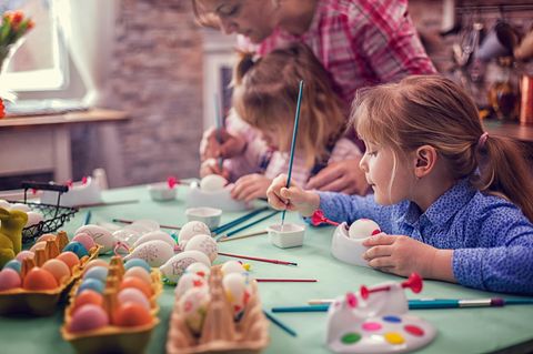 Kinder malen Ostereier an