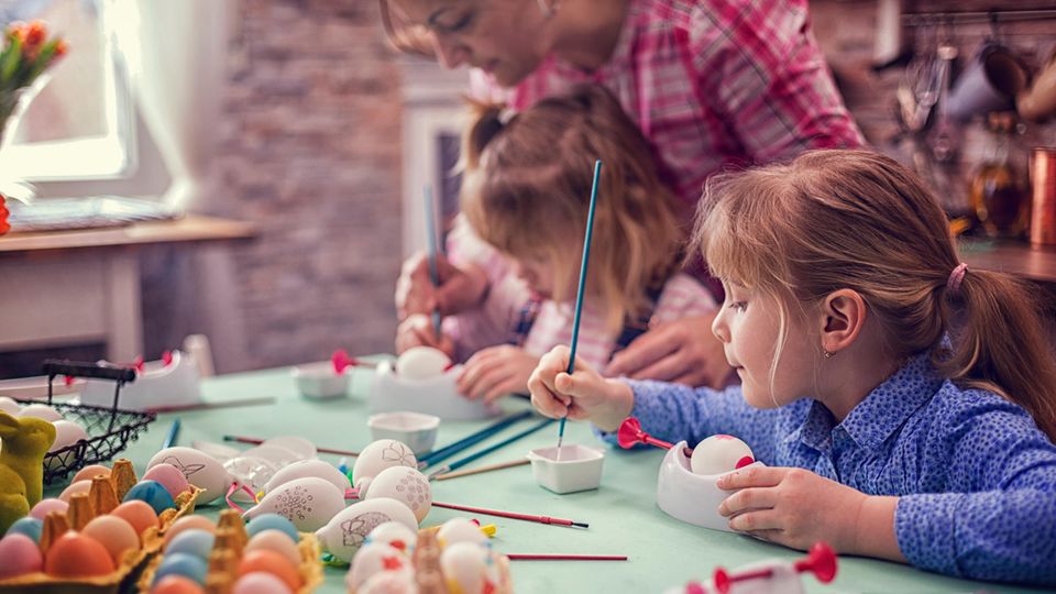 Kinder malen Ostereier an