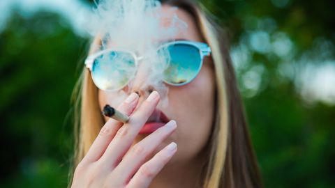 Eine junge Frau raucht einen Joint