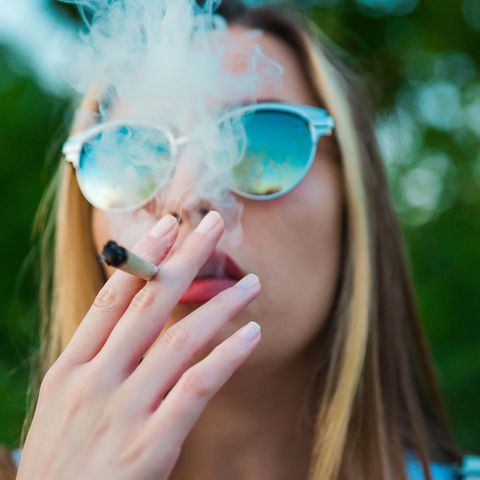 Eine junge Frau raucht einen Joint