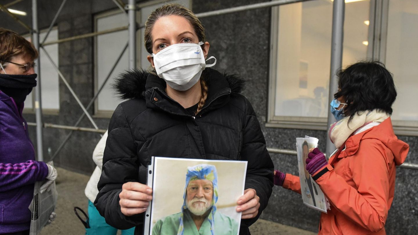 Eine Angestellte des Mount-Sinai-Krankenhauses in New York hält das Bild eines am Virus verstorbenen Kollegen hoch
