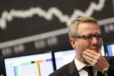 Ein Händler steht an der Börse vor der Dax-Kurve – das Coronavirus setzt der Weltwirtschaft zu