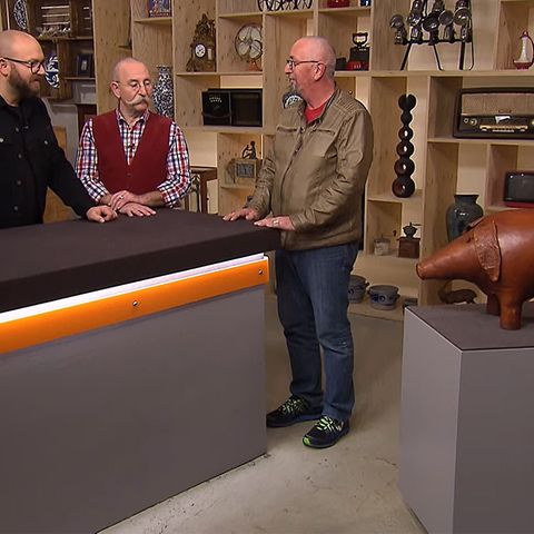 "Bares für Rares"-Experte Sven Deutschmanek und Moderator Horst Lichter bestaunen das Leder-Schwein von Klaus Groenewald.
