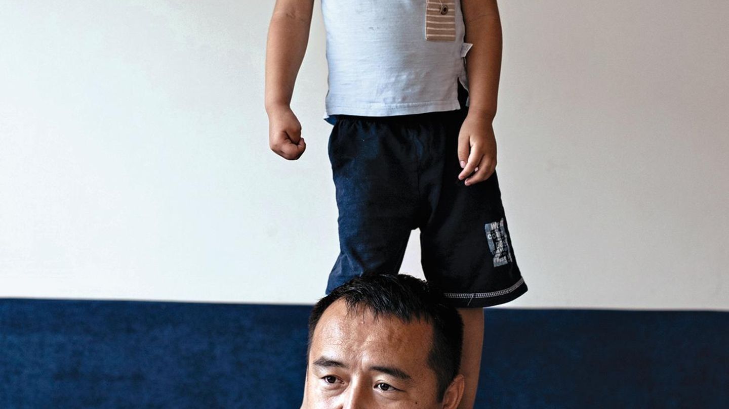 Serikjan in seiner Wohnung mit seinem Sohn Suleyman, 4