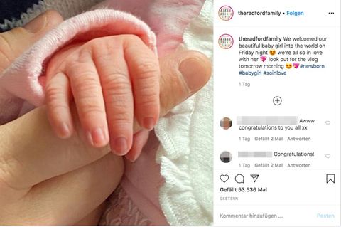 Die Hand des Neugeborenen in der Hand des Vaters