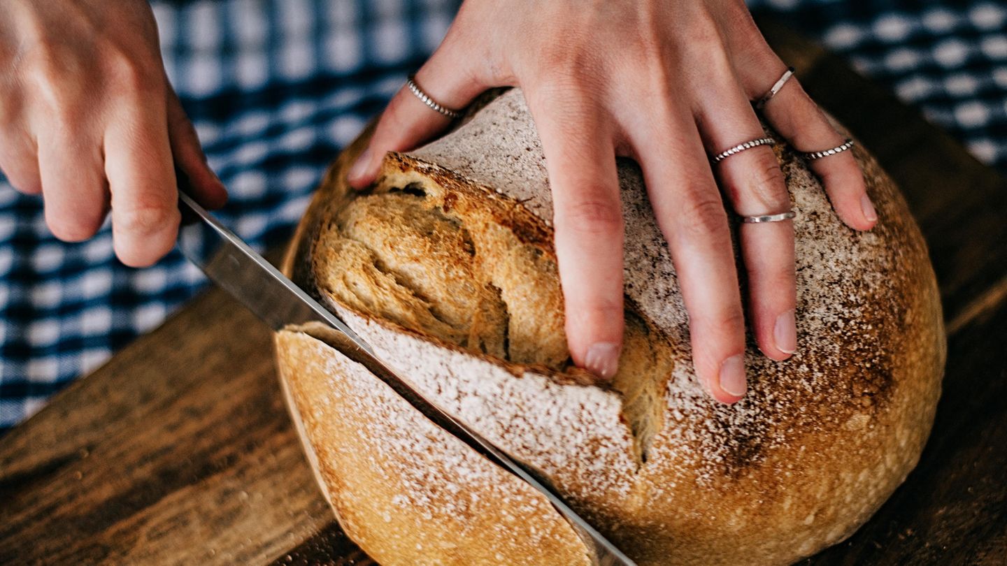 Ein Laib frisches Brot wird aufgeschnitten.