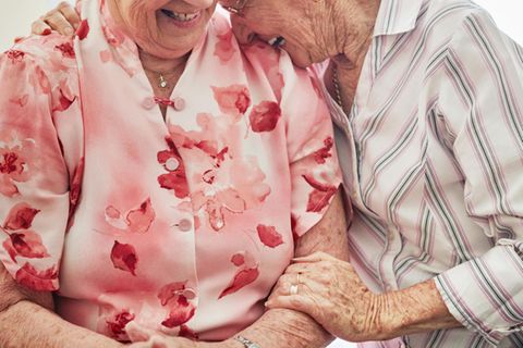 Alte Frauen umarmen sich und lachen
