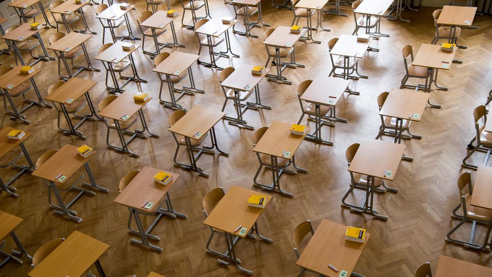 Durchnummerierte Tische stehen in einer Aula
