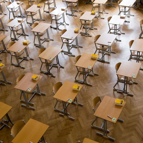Durchnummerierte Tische stehen in einer Aula