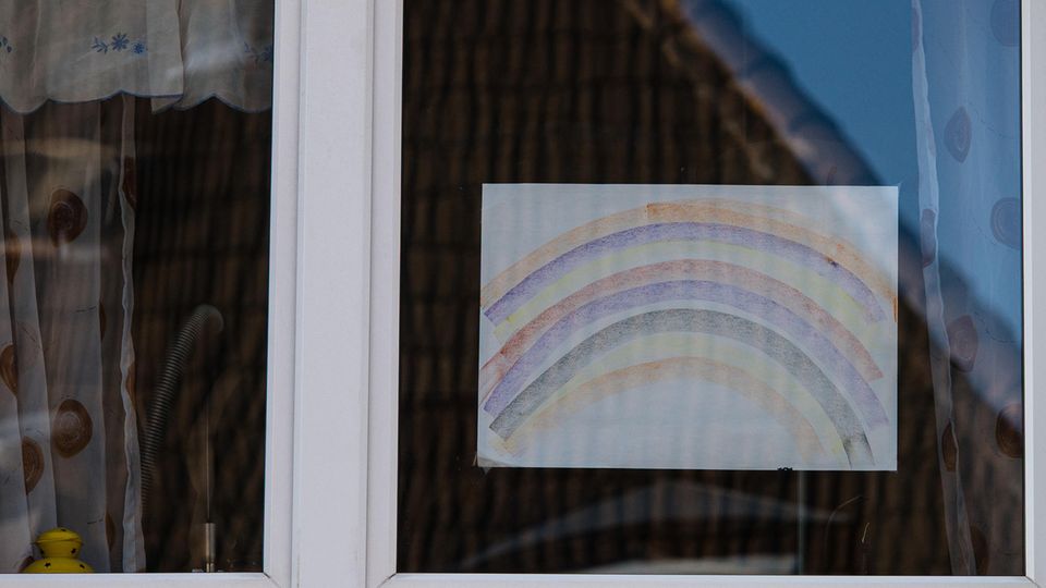 In einer Wohnung hängt eine Regenbogen-Zeichnung im Fenster