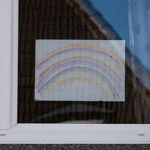 In einer Wohnung hängt eine Regenbogen-Zeichnung im Fenster