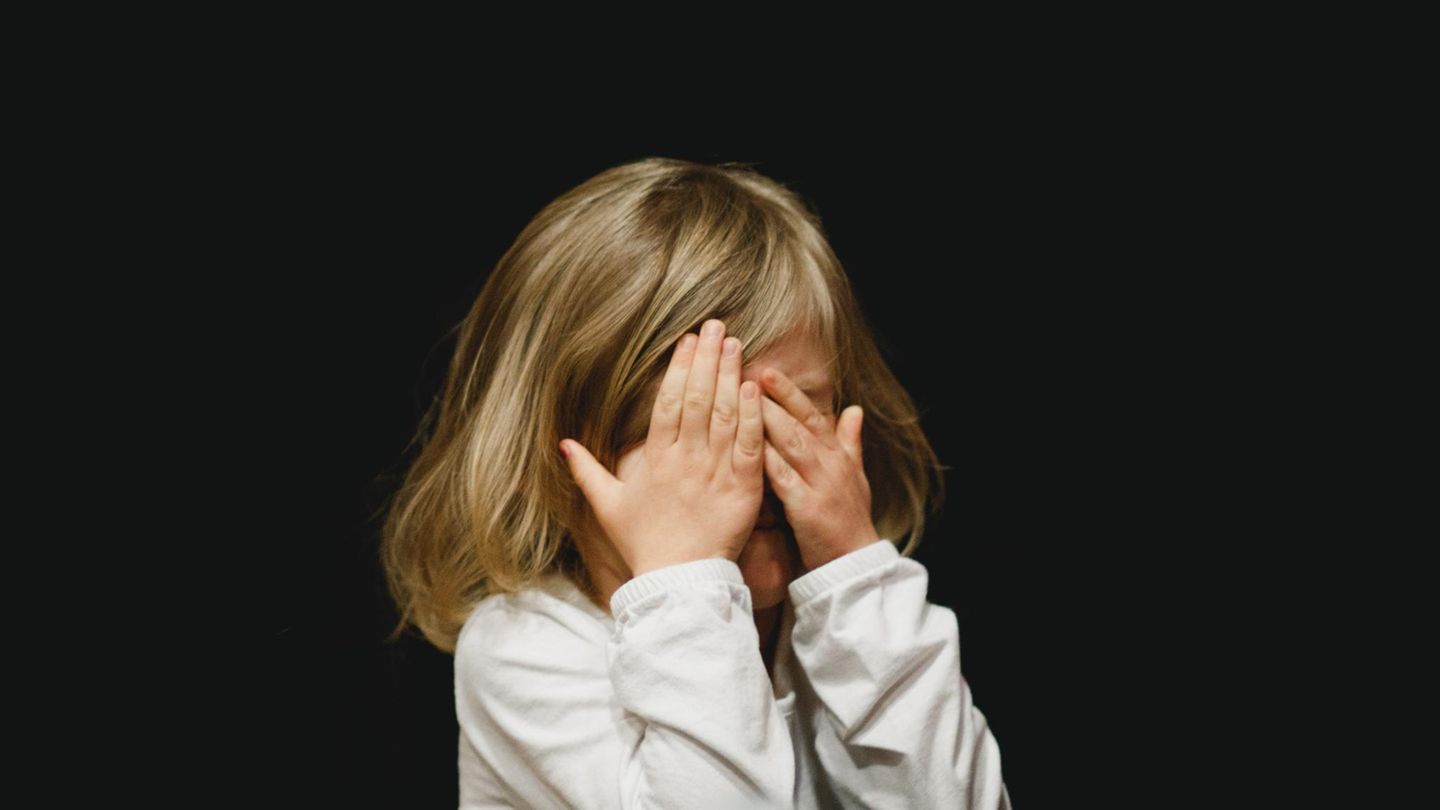 Ein mädchen hält sich die Augen zu
