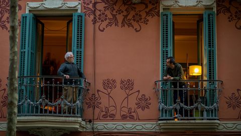 Spanien, Barcelona: Zwei Männer sprechen von ihren Balkonen aus