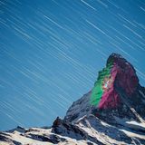 Langzeitbelichtung mit Sternenhimmel: die Fahne Portugals leuchtet an den Wänden.