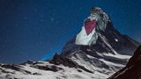 Auf das Weiß der noch vom Schnee bedeckten Ostwand wird ein rotes Herz projeziert...