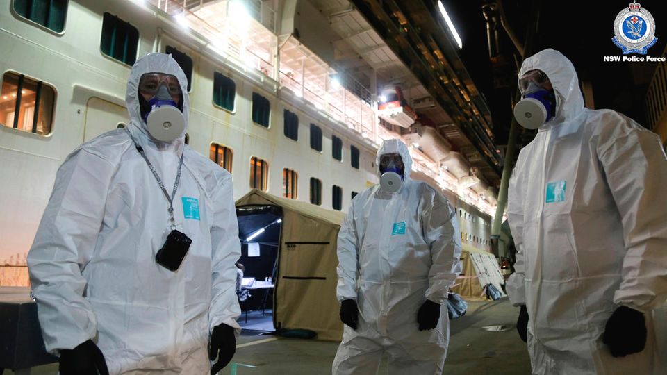 Princess Cruises: Polizisten in Schutzkleidung: Sie sind an Bord der "Ruby Princess" gegangen, um die Blackbox des Kreuzfahrtschiffes zu beschlagnahmen. Polizisten in Schutzkleidung: Sie sind an Bord der "Ruby Princess" gegangen, um die Blackbox des Kreuzfahrtschiffes zu beschlagnahmen.