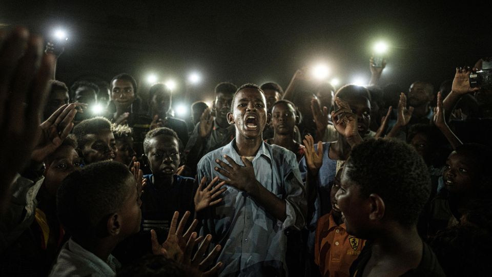 "World Press Photo of the Year" und Gewinner in der Kategorie "General News": Ein junger Mann rezitiert mitten in einer Gruppe von Demonstranten und im Schein vieler Handy-Lampen Gedichte in Sudans Hauptstadt Khartoum. Der japanische Fotograf Yasuyoshi Chiba ist mit diesem für die französische Agentur AFP aufgenommenen Foto "Straight Voice" Sieger des renommierten Wettbewerbs "World Press Photo 2020" und erhält den mit 10.000 Euro dotierten Preis, wie die Jury des Wettbewerbs "World Press Photo 2020" am 16.04.2020 in Amsterdam mitteilte.
