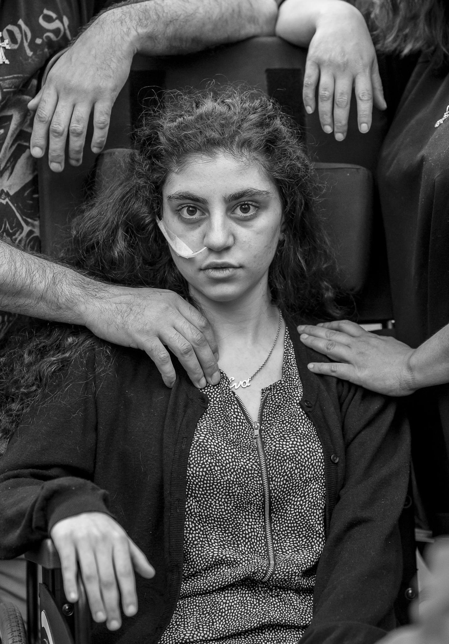 Awakening Gewinner in der Kategorie "Porträt": Ewa, ein 15-jähriges armenisches Mädchen, das kürzlich aus einem durch das Resignationssyndrom verursachten katatonischen Zustand erwacht ist, sitzt in einem Flüchtlingsaufnahmezentrum in einem Rollstuhl, flankiert von ihren Eltern. Titel des Fotos: "Awakening".