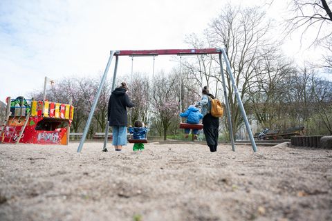 Zwei Mütter mit ihren Kindern auf dem Spielplatz