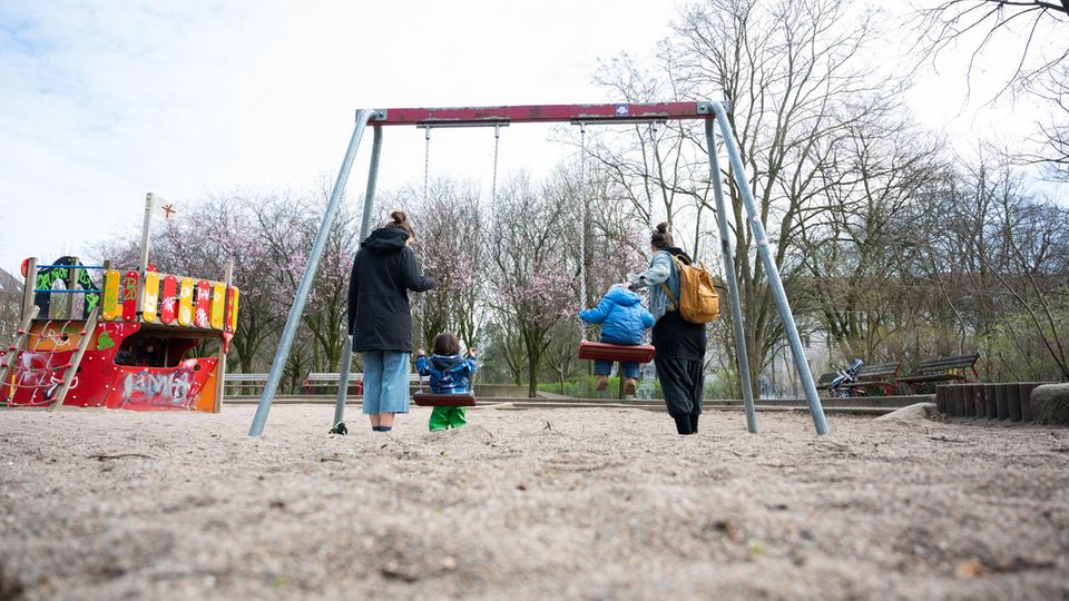 Zwei Mütter mit ihren Kindern auf dem Spielplatz Zwei Mütter mit ihren Kindern auf dem Spielplatz