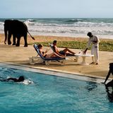 Menschen und ein Elefant zwischen Pool und Meer