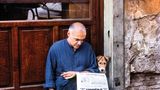 Ein Hund liest gemeinsam mit einem Mann die Tageszeitung