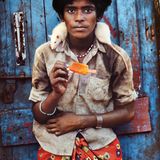 Ein junger Mann mit einer Ratte auf der Schulter isst ein Wassereis