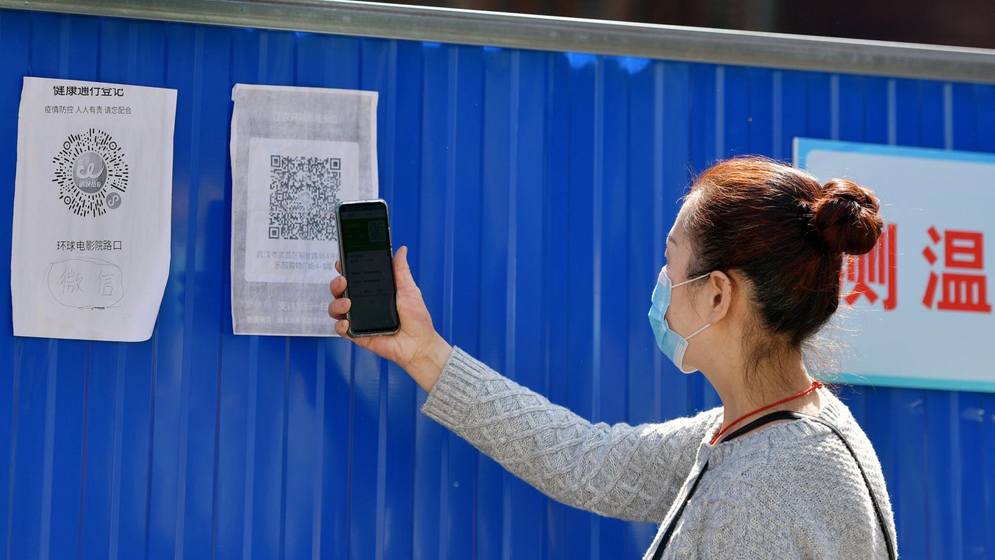 China, Wuhan: Eine Anwohnerin scannt einen Gesundheits-QR-Code am Eingang zu ihrer Gemeinde im Stadtbezirk Wuchang