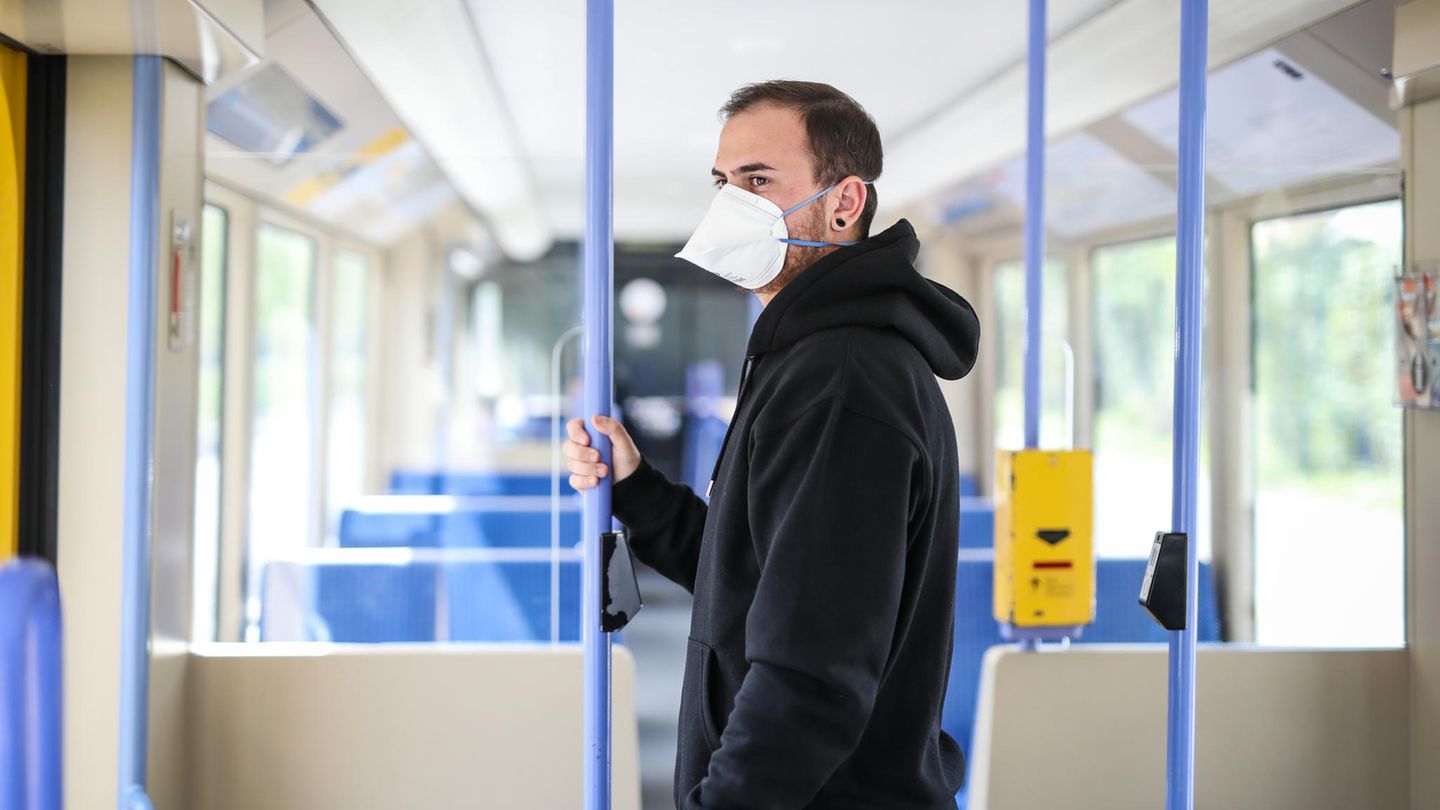 Ein junger Mann trägt in einer Stadtbahn eine Atemschutzmaske der Kategorie FFP2