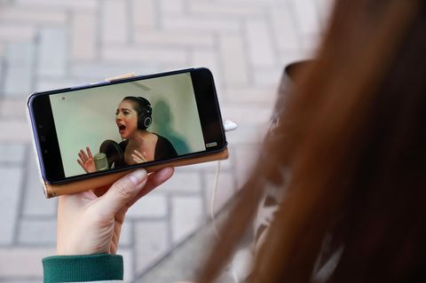 Die Japanerin Noemi sieht auf ihrem Smartphone die Live-Stream-Performance von Lady Gaga.