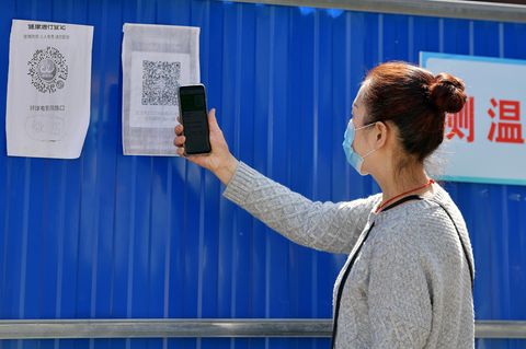Eine Anwohnerin scannt einen Gesundheits-QR-Code am Eingang zu ihrer Gemeinde im Stadtbezirk Wuchang