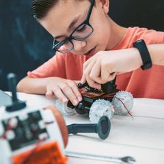 Teen boy Building robotic car for school assignment