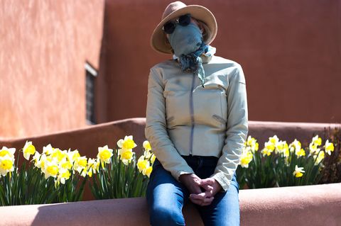 Eine Frau mit Schutzmaske und Sonnenbrille