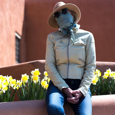 Eine Frau mit Schutzmaske und Sonnenbrille