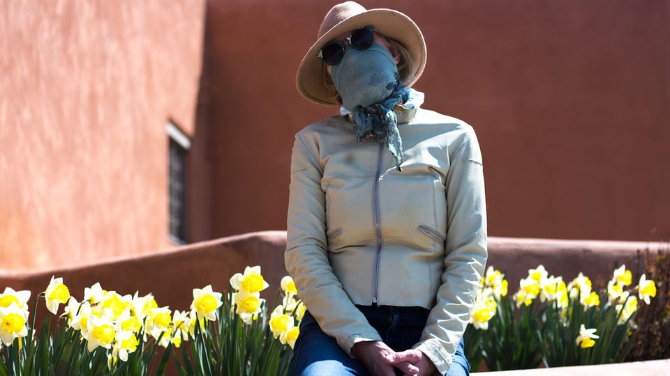 Eine Frau mit Schutzmaske und Sonnenbrille