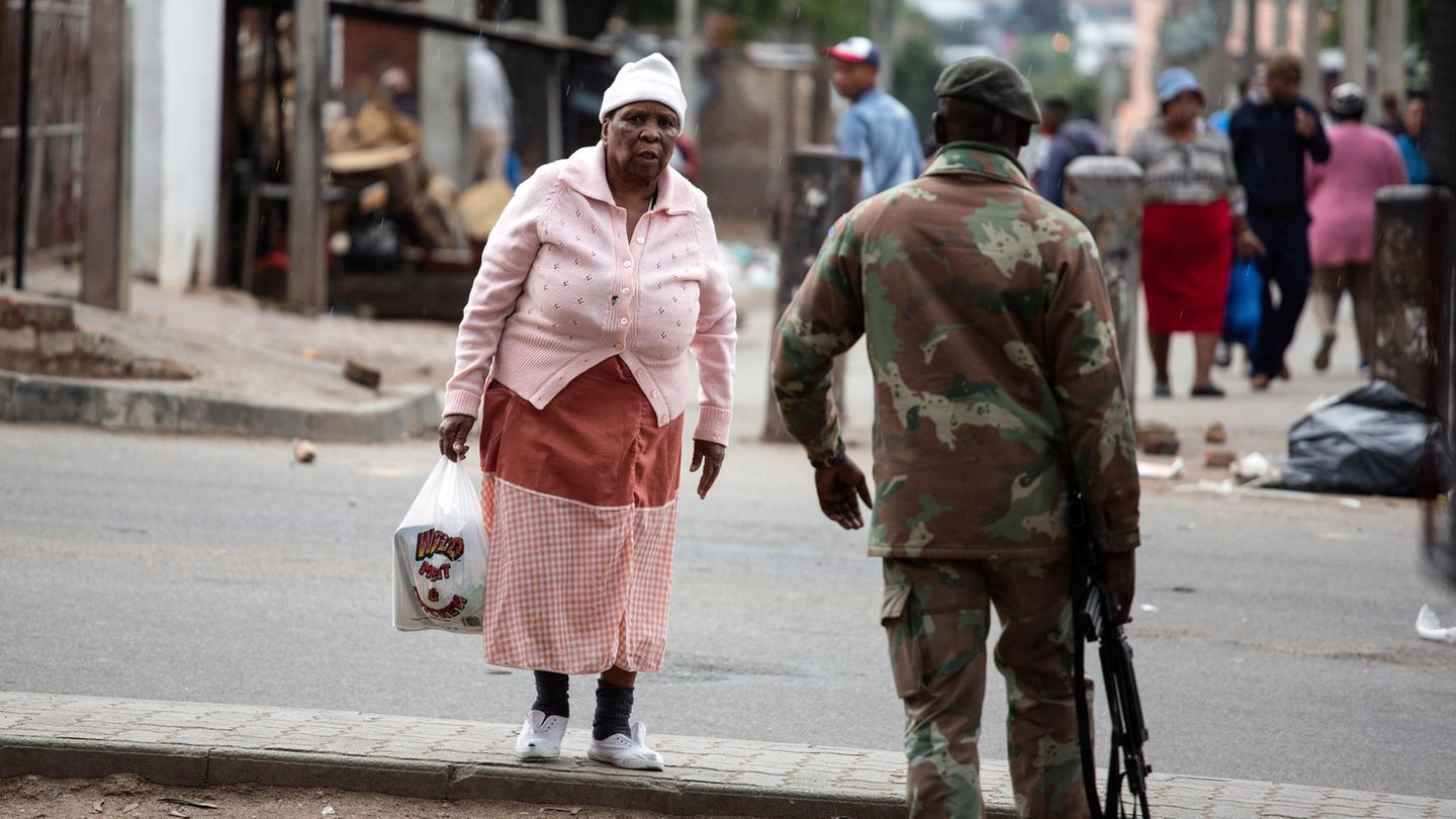 Eine ältere Frau passiert einen Soldaten Eine ältere Frau passiert einen Soldaten