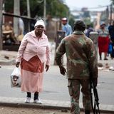 Eine ältere Frau passiert einen Soldaten