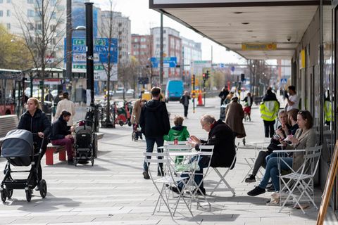 Menschen sitzen im Stadtzentrum von Stockholm vor einem Eiscafé